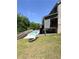 Manicured lawn slopes towards a backyard pool, set against a backdrop of lush greenery and privacy fencing at 4736 Landing Water Path, Buford, GA 30519
