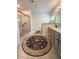 Well-lit bathroom with tiled walk-in shower, gray double sink vanity, and decorative rug at 4736 Landing Water Path, Buford, GA 30519