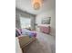 Bright bedroom boasts soft carpet, pink dresser, and a large window for natural light at 4736 Landing Water Path, Buford, GA 30519