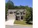 Beautiful two-story brick home with a manicured front lawn, attached two-car garage, and mature trees at 4736 Landing Water Path, Buford, GA 30519