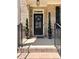 Close-up of a charming front door with decorative wreath, potted spiral topiaries, and elegant house number display at 4736 Landing Water Path, Buford, GA 30519