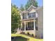 Beautiful front porch with brick stairs, columns, black railings, and seating, perfect for relaxing outdoors at 4736 Landing Water Path, Buford, GA 30519