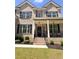Inviting front porch with brick stairs, black railings, columns, and a well-maintained lawn and landscaping at 4736 Landing Water Path, Buford, GA 30519