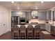 Modern kitchen featuring stainless steel appliances, gray cabinets, a kitchen island, and an open layout for contemporary living at 4736 Landing Water Path, Buford, GA 30519