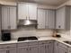 Modern kitchen showcases grey cabinets, white countertops, stainless appliances, and modern finishes for a sleek design at 4736 Landing Water Path, Buford, GA 30519