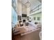 Grand living room with a stone fireplace, built-in shelving, a high ceiling, and large windows at 4736 Landing Water Path, Buford, GA 30519
