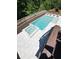Aerial view of the backyard swimming pool and spa area with light stone patio and wooden fence at 4736 Landing Water Path, Buford, GA 30519