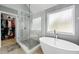 This spacious bathroom features stand-up shower with glass door and a modern soaking tub at 1892 Ivy View Walk, Loganville, GA 30052