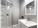 This modern bathroom features a stand-up shower with glass door, plus a sink with a large mirror at 1892 Ivy View Walk, Loganville, GA 30052