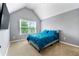 Cozy bedroom with a large window, carpeted floor, and comfortable blue bedding at 1892 Ivy View Walk, Loganville, GA 30052