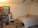 Neutral bedroom featuring a cozy bed, plush ottoman, and well-stocked bookshelf at 2494 Bronco Trl, Duluth, GA 30096