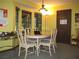 Bright dining room with a light-colored table set for six, featuring a bay window and overhead lighting at 2494 Bronco Trl, Duluth, GA 30096