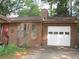 Side view of home, showcasing a white garage door, siding, and a glimpse of the well-manicured lawn at 2494 Bronco Trl, Duluth, GA 30096