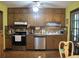 Functional kitchen featuring wooden cabinets, tile countertops, and modern stainless steel appliances at 2494 Bronco Trl, Duluth, GA 30096