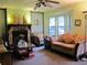 Cozy living room with a stone fireplace, comfortable seating, and a bay window for natural light at 2494 Bronco Trl, Duluth, GA 30096