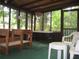Enclosed sunroom with a green floor, table and chairs, with views of the trees outside at 2494 Bronco Trl, Duluth, GA 30096
