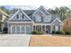 Charming two-story home featuring a brick and gray facade, attached two-car garage, and well-manicured lawn at 55 Little Barley Nw Ln, Grayson, GA 30017