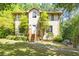 Inviting exterior featuring a stucco facade, wooden stairs leading to the front door, and lush landscaping at 1105 Mitchell Crossing Sw Dr, Atlanta, GA 30331