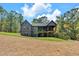 A spacious backyard with an expansive lawn leading up to a home with a covered patio and porch at 33 Cedar Gate Ln, Kingston, GA 30145