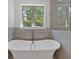 A freestanding tub sits in front of a window in this bright and modern bathroom at 33 Cedar Gate Ln, Kingston, GA 30145