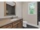 Stylish bathroom boasts dark, hexagonal tiles, wood cabinets, and a granite countertop at 33 Cedar Gate Ln, Kingston, GA 30145