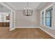 Dining area featuring hardwood floors, a modern chandelier, and abundant natural light from the large windows at 33 Cedar Gate Ln, Kingston, GA 30145