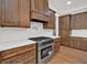 Close-up of the kitchen's stove and cooktop with custom wood cabinets and countertops at 33 Cedar Gate Ln, Kingston, GA 30145