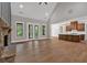 Expansive living room with vaulted ceiling, stone fireplace, hardwood floors, and seamless transition to the kitchen at 33 Cedar Gate Ln, Kingston, GA 30145