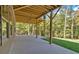 Large concrete patio with wood beam ceiling offers seamless indoor/outdoor living, with a lush tree backdrop at 33 Cedar Gate Ln, Kingston, GA 30145