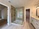 Modern bathroom featuring tile shower, soaking tub, vanity, and walk-in closet at 655 Wellingborough Ct, Alpharetta, GA 30005