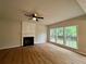 Bright living room with fireplace, ceiling fan, and large windows at 655 Wellingborough Ct, Alpharetta, GA 30005