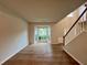 Open living room featuring hardwood floors, a staircase, and a bright bay window at 655 Wellingborough Ct, Alpharetta, GA 30005