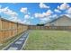Spacious fenced backyard with a stone walkway and a lush green lawn, perfect for recreation at 1603 Maston Rd, Auburn, GA 30011