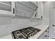 New kitchen with stainless steel stovetop and modern white quartz countertops and cabinets at 1603 Maston Rd, Auburn, GA 30011