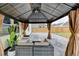 Covered outdoor patio featuring a seating area, landscaping, and a view of the fenced backyard at 1603 Maston Rd, Auburn, GA 30011