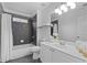 Modern bathroom with gray tiling, a shower-tub combo, and a sleek white vanity at 1783 Drew Nw Dr, Atlanta, GA 30318