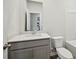 Bathroom with grey cabinets, white countertops, toilet and a large framed mirror at 3970 Brushy St, Powder Springs, GA 30127