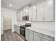 Kitchen with stainless steel appliances, white cabinets and countertops and light gray backsplash at 3970 Brushy St, Powder Springs, GA 30127