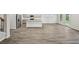 Open concept living room with stainless steel kitchen appliances, island, and luxury vinyl flooring at 3970 Brushy St, Powder Springs, GA 30127