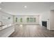 Open-concept living area with hardwood floors, a cozy fireplace, and large windows for natural light at 3970 Brushy St, Powder Springs, GA 30127