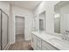 Bathroom features tiled shower, white cabinets, quartz countertops, dual sinks, and wood-look floors at 3974 Brushy St, Powder Springs, GA 30127