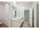 Bathroom features tiled shower, white cabinets, quartz countertops, dual mirrors, and wood-look floors at 3974 Brushy St, Powder Springs, GA 30127