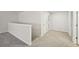 Well-lit hallway with neutral carpet and white walls leading to other rooms in the home at 3974 Brushy St, Powder Springs, GA 30127