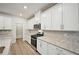 Modern kitchen featuring white cabinets, granite countertops, stainless steel appliances and backsplash at 3974 Brushy St, Powder Springs, GA 30127