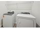Well-lit laundry room with a new washer, dryer, and overhead wire shelving for storage at 3974 Brushy St, Powder Springs, GA 30127