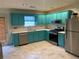 Updated kitchen featuring stainless appliances, light countertops, and unique teal cabinetry at 4585 Post Ridge Ln, Lithonia, GA 30038