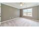 Spacious bedroom with light-colored carpet, ceiling fan, and large window at 1349 Mckinsey Rdg, Loganville, GA 30052
