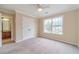 Bright bedroom featuring neutral carpeting, ceiling fan, and large window for natural light at 1349 Mckinsey Rdg, Loganville, GA 30052