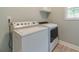 Functional laundry room with a washer, dryer, upper cabinet, and neutral flooring at 1349 Mckinsey Rdg, Loganville, GA 30052