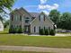 Inviting two-story home with manicured lawn and charming curb appeal under a beautiful sky at 4279 Persian Ct, Snellville, GA 30039